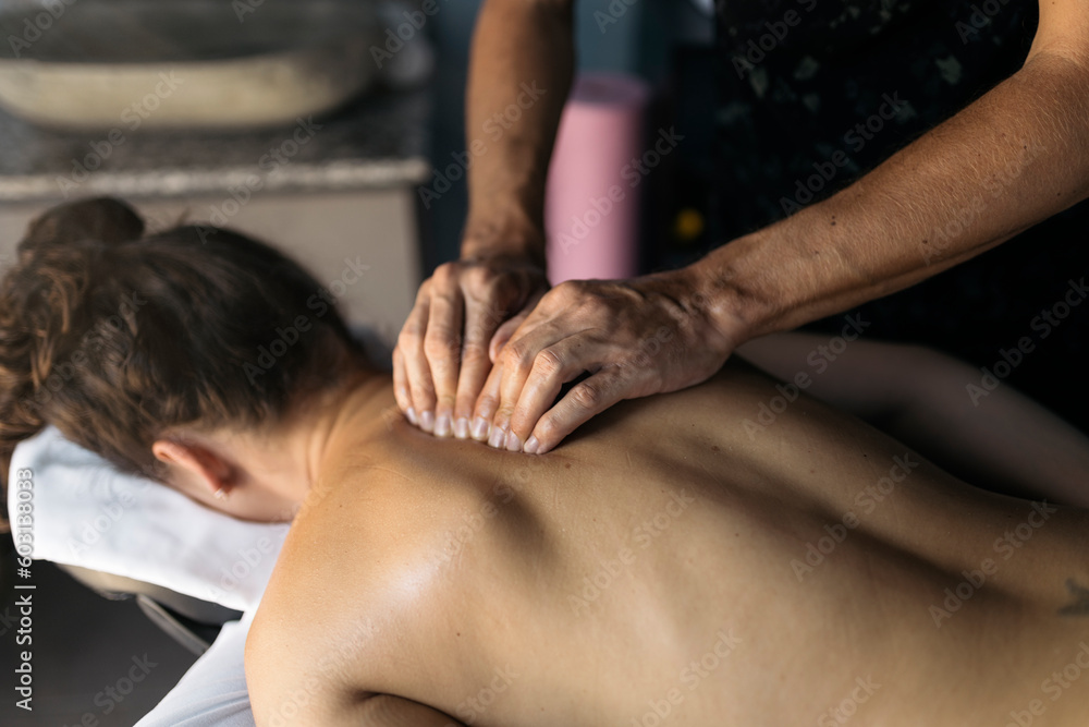 Physiotherapist treating the back of a patient Physiotherapist treating the back of a patient