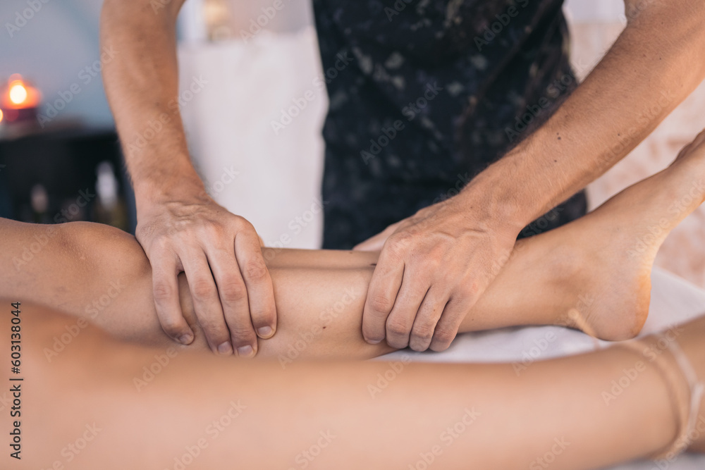 Close up of hands of masseuse massaging calves Close up of hands of masseuse massaging calves