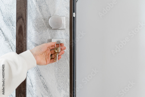 Woman hand opening the front door with the metal key