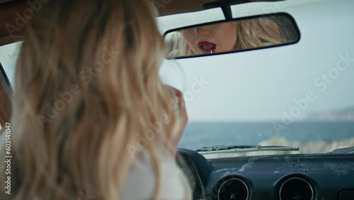 Wallpaper Mural Gorgeous woman applying lipstick looking in car mirror close up. Lips makeup Torontodigital.ca