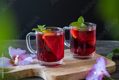 Red Hot Hibiscus tea in a glass mug on a wooden table 