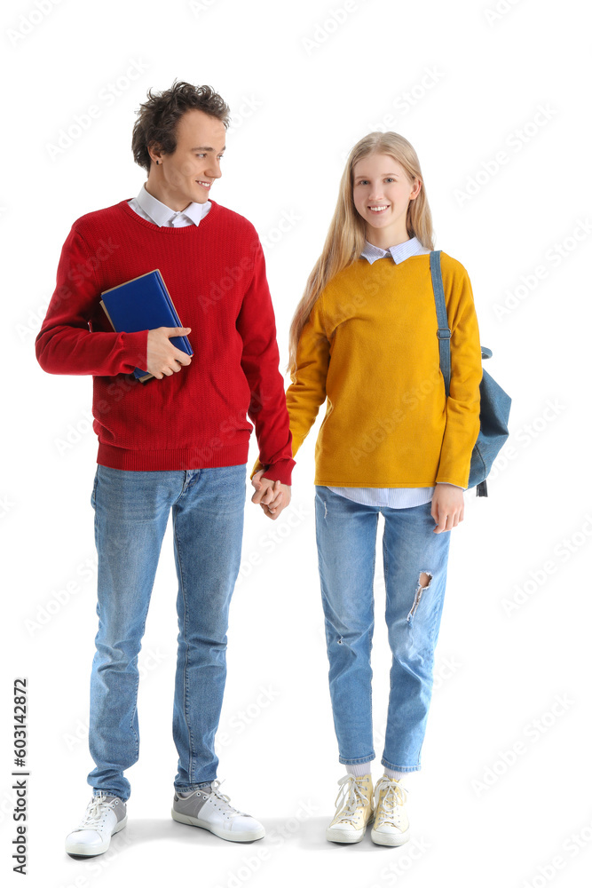 Teenage couple with books holding hands on white background Teenage couple with books holding hands on white background