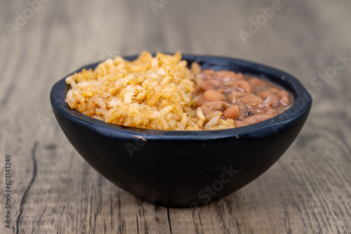 Half and half bowl of whole pinto beans and Mexican rice for a meal side order