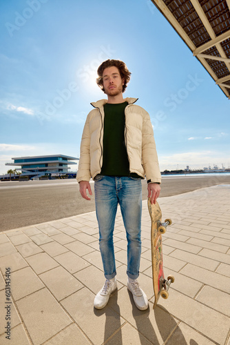 Cool young guy looking at camera in skate park photo