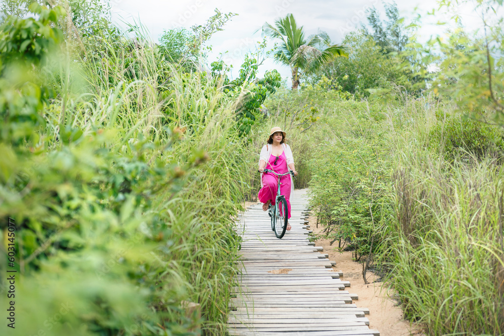 Plus size asian woman wearing a hat enjoying time at the beach