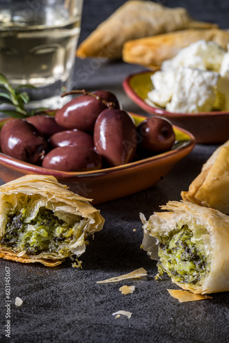 Greek spanakopita in phyllo dough. Greek olives in the background.