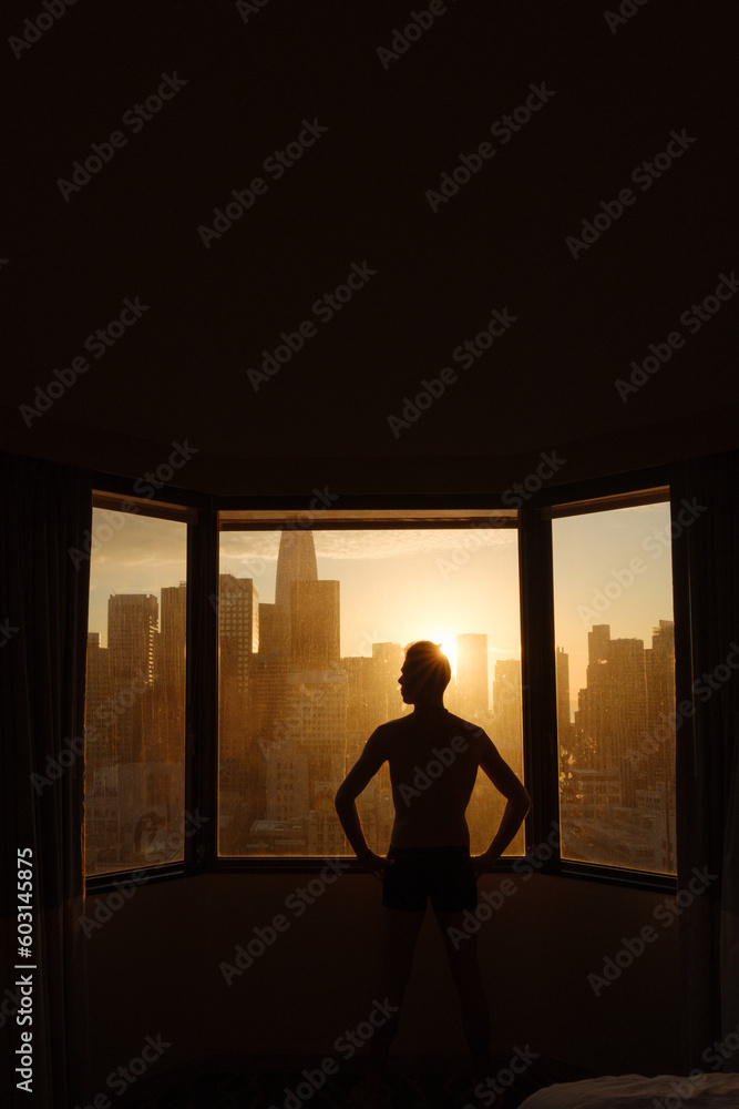 Man in Hotel Looking at Sunrise View Man in Hotel Looking at Sunrise View
