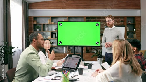 Marketing strategy analysis, stock market trading or corporate teamwork. A team of startups at a table with a large green screen TV. Mixed race business team.