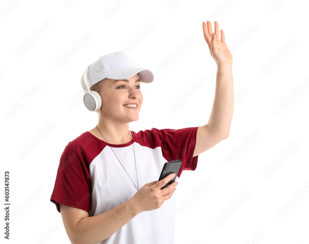 Young woman with headphones and mobile phone waving hand on white background Young woman with headphones and mobile phone waving hand on white background