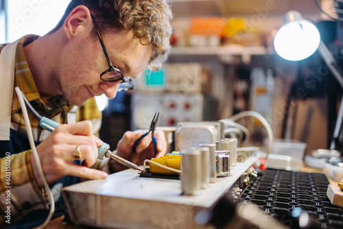 Repairman fixing circuit board of guitar amplifier