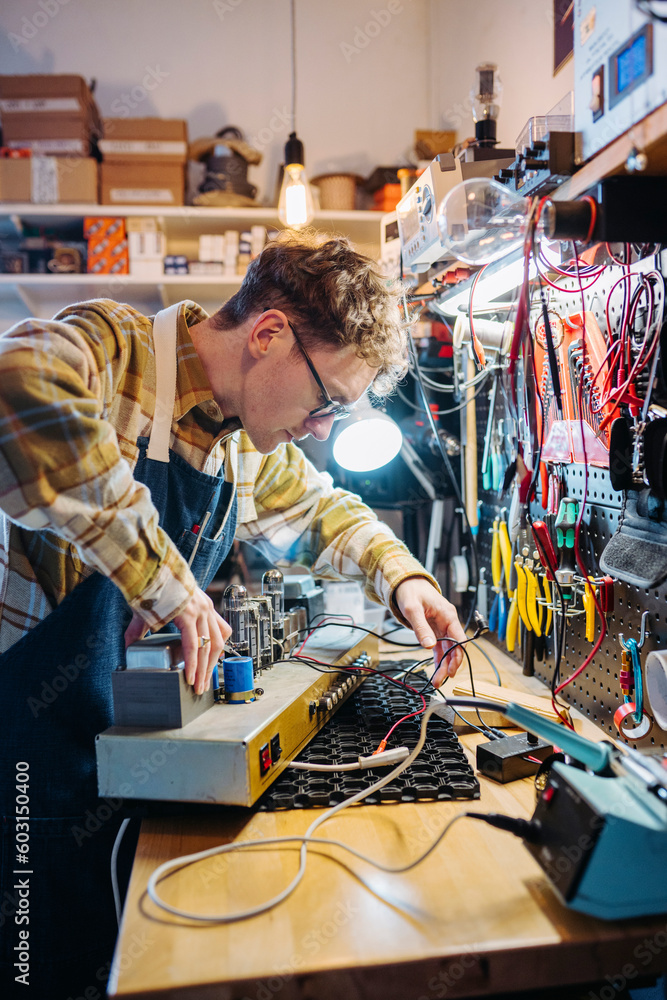 Busy male in guitar amplifier workshop Busy male in guitar amplifier workshop