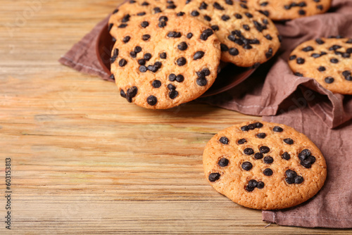 Tasty cookies with chocolate chips on wooden background