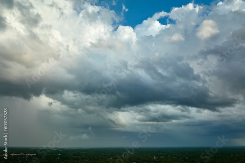 Dark stormy clouds forming on gloomy sky before heavy rainfall over suburban town area