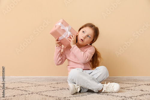Little girl with gift sitti...