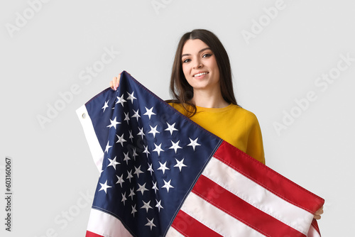 Young woman with USA flag on light background photo