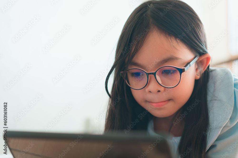 A young girls use laptop computers and tablets to find educational information at home. A young girls use laptop computers and tablets to find educational information at home.