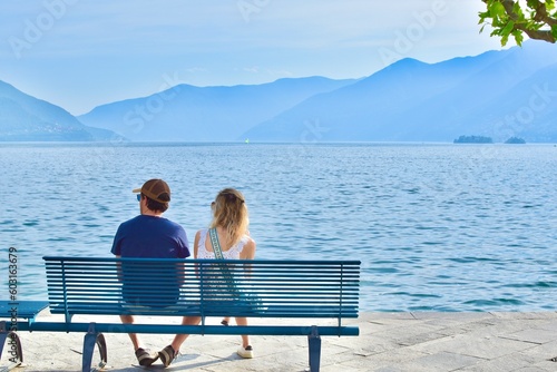 Fotografie man and woman sitting on a bench by the lake