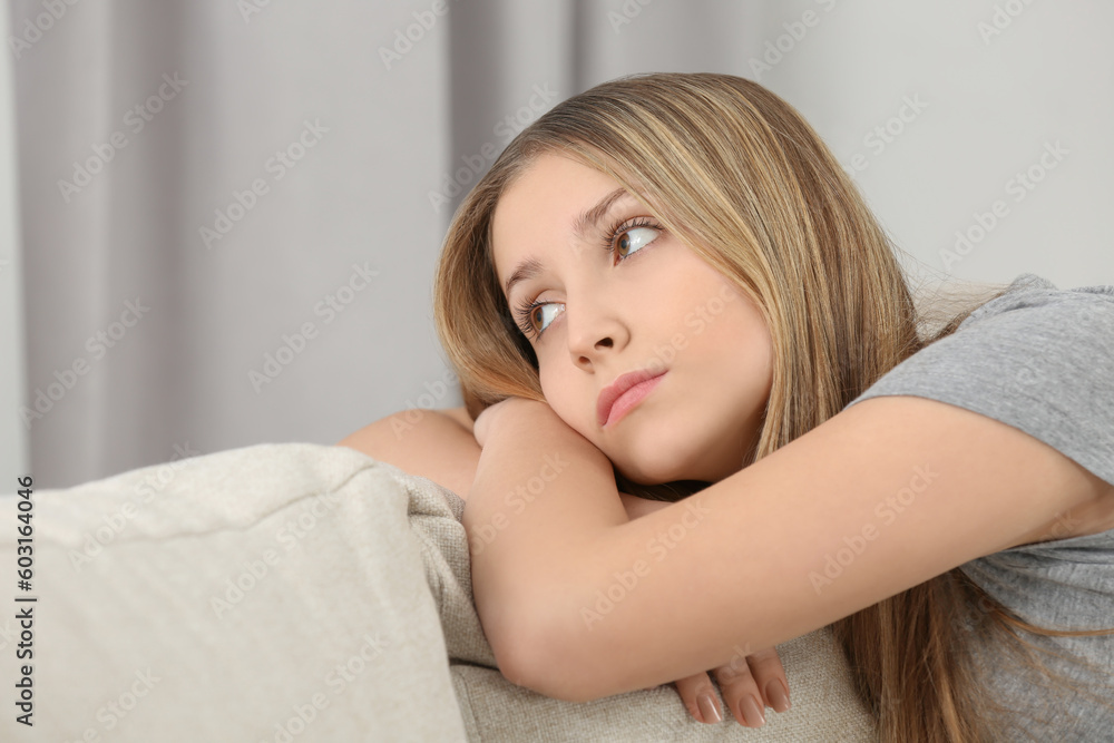 Upset teenage girl on sofa at home Upset teenage girl on sofa at home