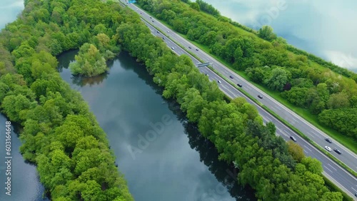 Drone shot over Unterbacher See Lake in Dusseldorf, Germany. Beautiful blue fresh lake water and many green trees and bushes on the coast with beaches and boats sailing under the spring blue sky    photo