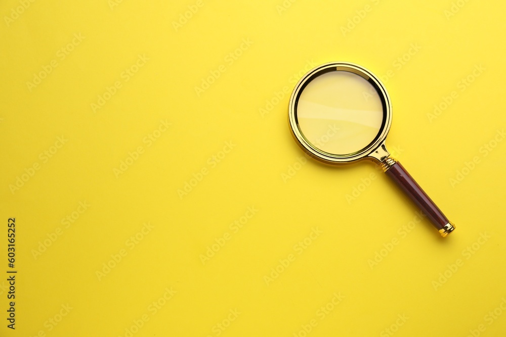Magnifying glass on yellow background, top view. Space for text Magnifying glass on yellow background, top view. Space for text