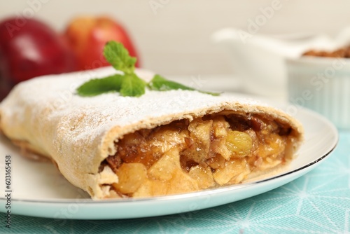 Delicious strudel with apples, nuts and raisins on table, closeup
