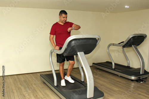 Forty-year-old dark-haired Latino adult man exercises his legs on the treadmill as a treatment for diseases such as tendonitis, tendon rupture or cruciate ligament injury