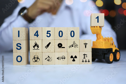 ISO 45001 concept which is a safety standard in the workplace or establishment, is something that must be given priority. Safety warning icons on wooden blocks.