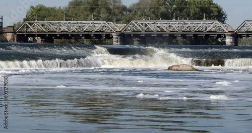 Looking up the river Trent weir with the Trent Railway line bridge in background, by Ratcliffe on Soar Power station. Wide shot photo