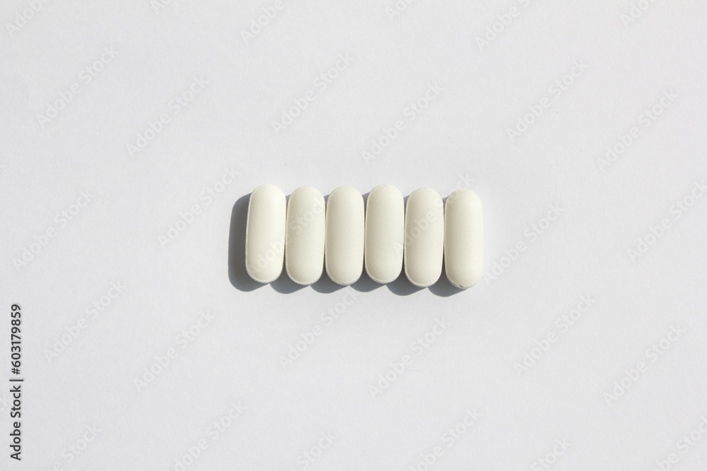 white pills on a white background white pills on a white background
