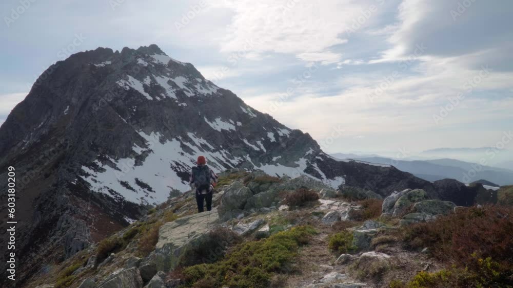 Young female hiking towards the Torres peak in Picos de Europa in Asturias on a sunny day Young female hiking towards the Torres peak in Picos de Europa in Asturias on a sunny day