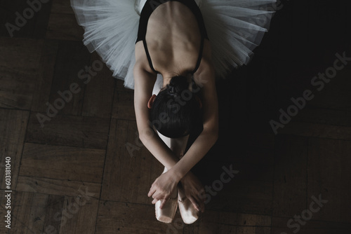 Teenage ballerina stretching on the floor
