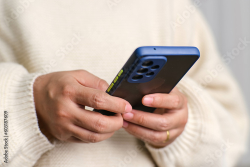 Wallpaper Mural Closeup of female hand holding smartphone checking social media, playing games, online shopping relaxing on sofa. Lifestyle, free time and relaxation. Torontodigital.ca