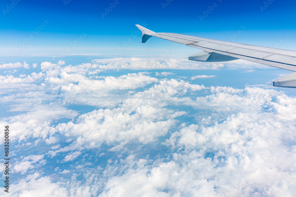 View from the airplane window at a beautiful cloudy sky and the airplane wing View from the airplane window at a beautiful cloudy sky and the airplane wing