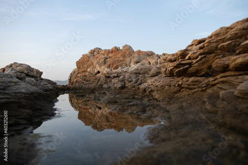 Two Sardinian rocks "kissing" each other and their mirror reflection in the still water of Porto Rotondo beach, Costa Smeralda, Italy