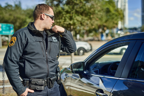 Canvas Print Police, radio and security with a man officer outdoor on patrol while talking to headquarters for a situation report