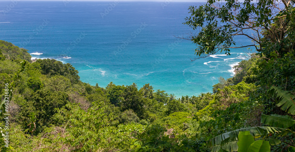 looking down on Freedom Beach Phuket Thailand. Magnificent colours in the sky and turquoise blue waters and white sandy beach through the lush green colours of the rainforest 