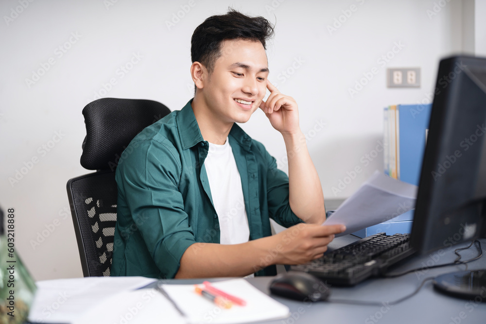 Photo of young Asian businessman working at office Photo of young Asian businessman working at office