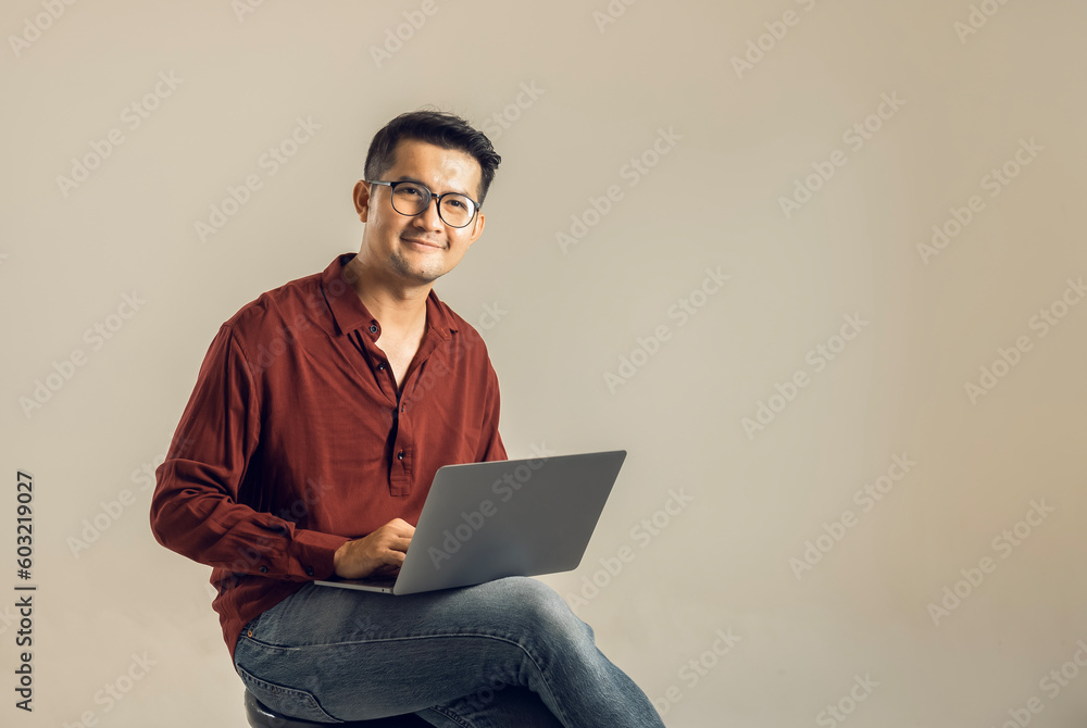 Simple young freelancer sitting working on laptop pc computer looking isolated on bright colored wall, studio photo background. Simple young freelancer sitting working on laptop pc computer looking isolated on bright colored wall, studio photo background.