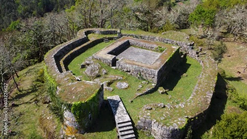 Top to bottom pan dron aerial shot of the ruins from a castle on the Valley of the Rial Stream, at A Peroxa, Ourense, Spain. photo