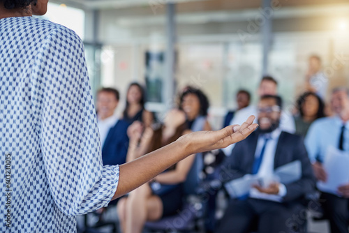 Presentation, hand and a woman as speaker at a conference for training or workshop. Business, corporate and a female manager speaking to a crowd at a seminar or convention for leadership or mentoring