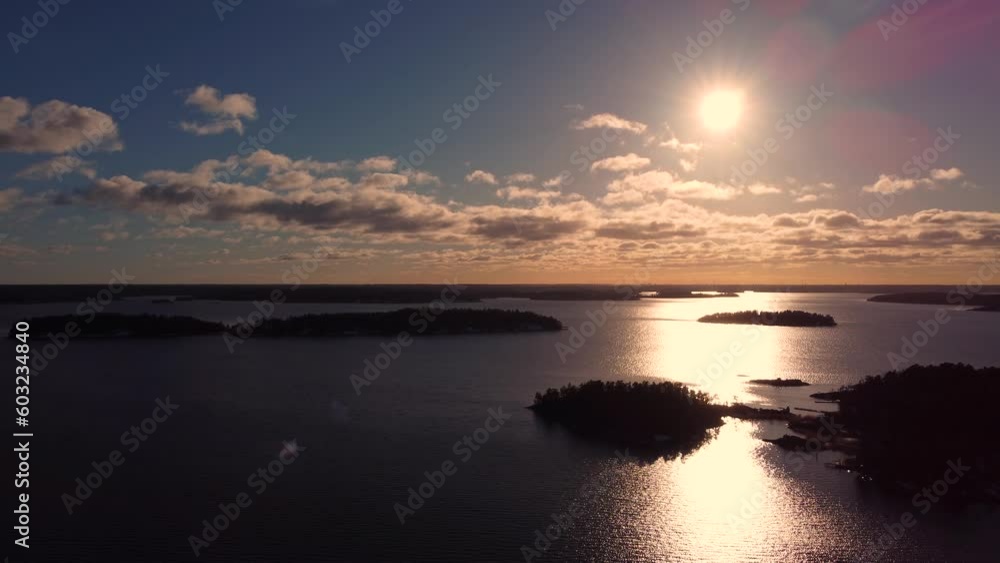 Static aerial of sunset reflected on surface by Baltic Sea islands