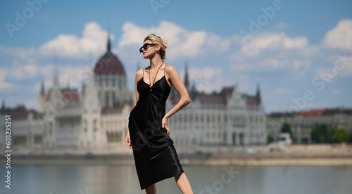 Beautiful sexy model posing outdoor. Luxury travel in Budapest Hungary. Sensual woman on the street near Budapest Parliament in Hungary. photo