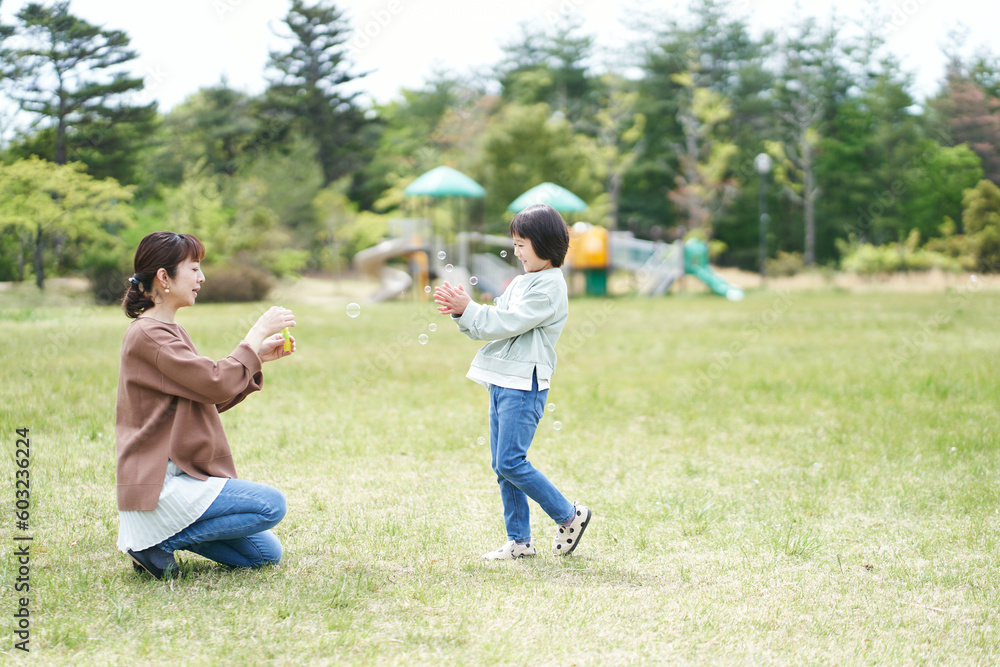 公園でシャボン玉で遊ぶ親子 公園でシャボン玉で遊ぶ親子