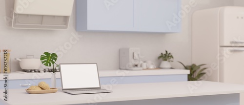 A laptop mockup on a white kitchen island in minimal kitchen in white and blue style. © bongkarn
