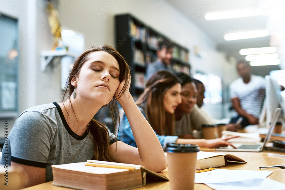 Fototapeta premium Woman, tired and books for studying at library, college or campus with stress, anxiety or burnout. University student, girl and headache with education, study and fatigue on face at school with sleep