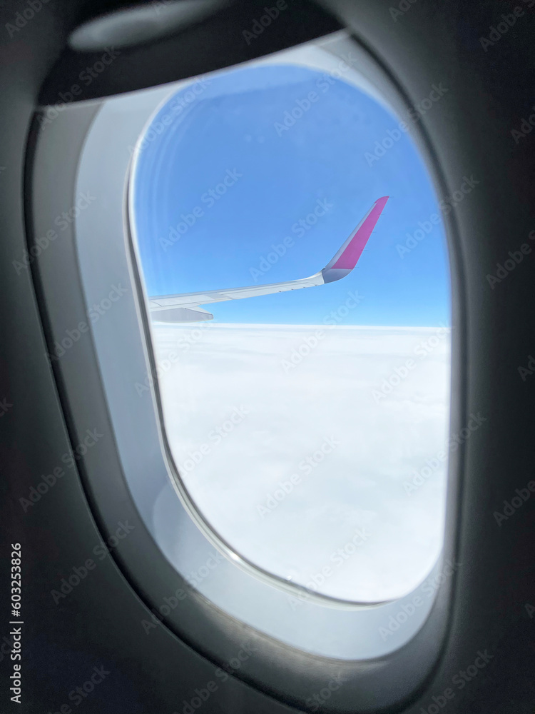 View from the airplane window. Beautiful cloudscape with blue sky. Wonderful panorama above white clouds as seen through window of an plane. View from the airplane window. Beautiful cloudscape with blue sky. Wonderful panorama above white clouds as seen through window of an plane.