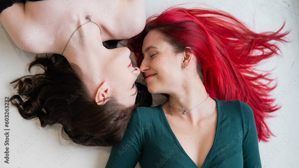 Fototapeta premium Top view of caucasian women lying and kissing. 
