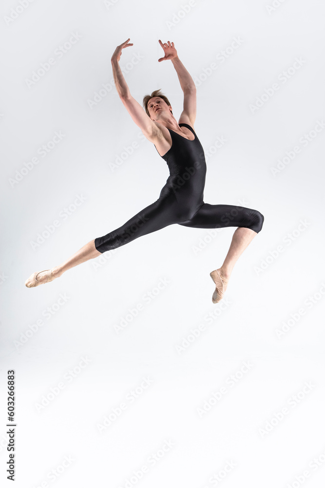 One Caucasian Ballet Dancer Young Athletic Man in Black Suit Posing Dancing in Studio On White.