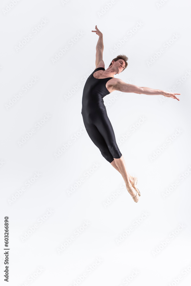 Fototapeta premium Ballet Dancer Young Man in Black Dance Suit Posing in Flying Ballanced Dance Pose Studio On White.