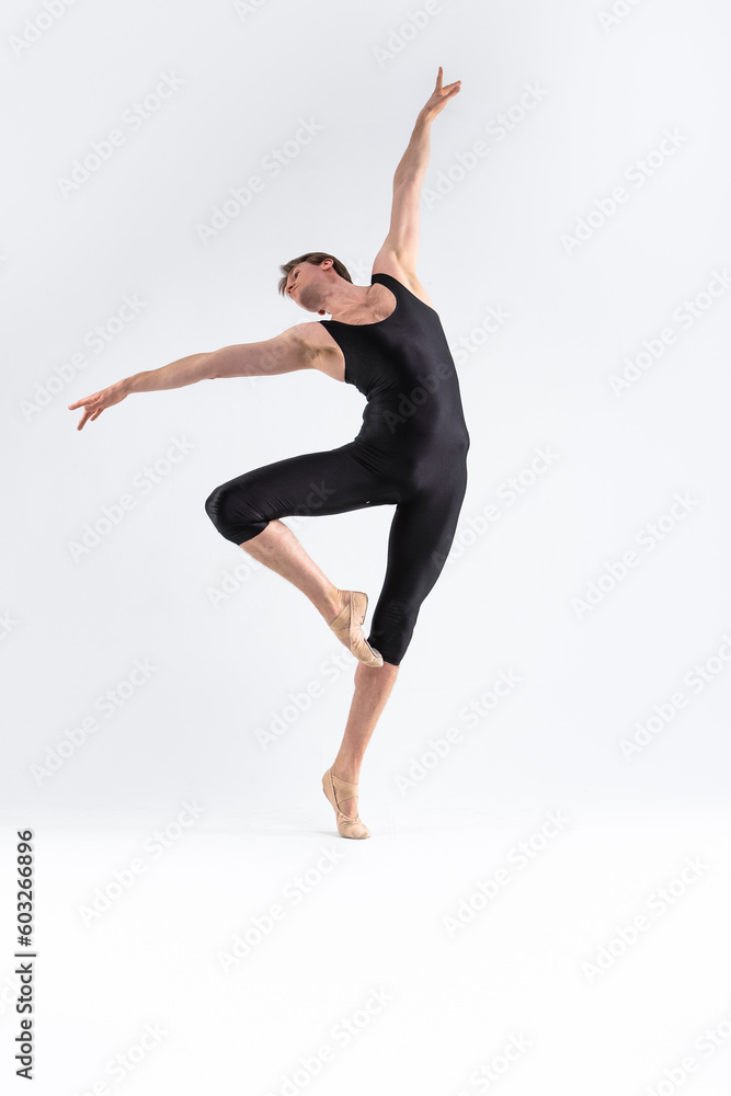 male Ballet Dancer Young Athletic Man in Black Suit Posing in Ballanced Stretching Dance Pose Studio On White.